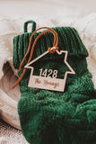 Wooden House shaped ornament cut with the house number and engraved with The Youngs with a Suede Tie placed on a Green Christmas Stocking