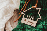 Wooden House shaped ornament cut with the house number and engraved with The Youngs with a Suede Tie placed on a Green Christmas Stocking