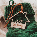 Wooden House shaped ornament cut with the house number and engraved with The Youngs with a Suede Tie placed on a Green Christmas Stocking