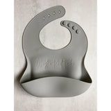 Gray silicone bib engrave with first, middle, and last name on a concrete background