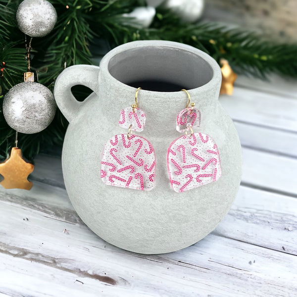 Clear earrings with candy canes printed on them
