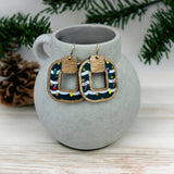 A beautiful pair of earrings with a wooden layer with Christmas patterned acrylic with Christmas Decor in the background