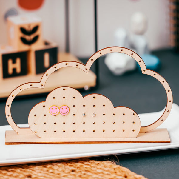 Laser Cut wooden cloud shaped earring holder with two pairs of children's earrings for display  