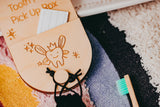 Wooden tooth fairy box with a cartoon tooth design on a textured surface.