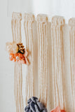 Detail showing how the hair bows are hung on the cotton strings that hang from the half acrylic circle. On a white background.