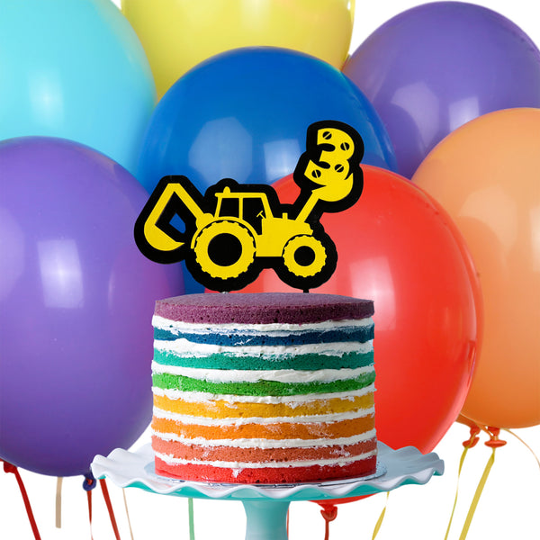 Black and Yellow Backhoe cake topper on a rainbow cake with balloons in the background by Legacy and Light 