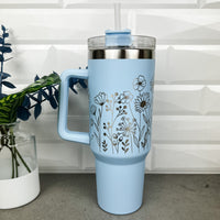 Light Blue 40 oz tumbler with a handle and straw laser engraved with a floral design
