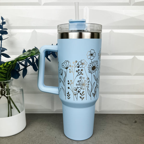 Light Blue 40 oz tumbler with a handle and straw laser engraved with a floral design