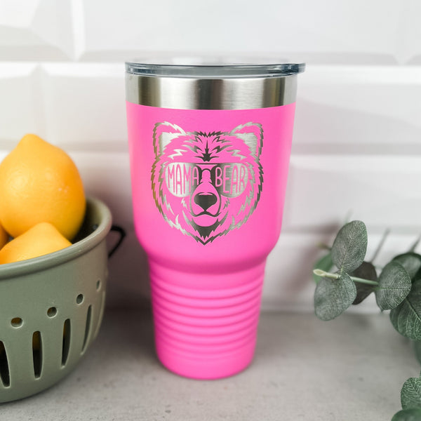 A Hot pink stainless steel tumbler with a mama bear design laser engraved into the powder coating 