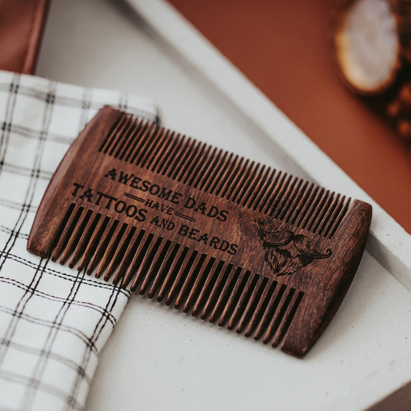 Wooden beard comb with laser engraved Awesome Dads have tattoos and beards on white tray by Legacy and Light