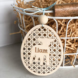 Laser cut and engraved natural Birch wood basket name tag. Egg shaped with intricate cut pattern and a lamb in the center personlized name in the center of the lamb. Tag is atttached to a wire basket.