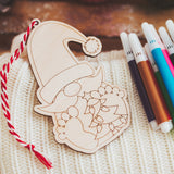 Color your own Christmas Ornament with mini markers. As pictured a Santa face with two feet below his mustache and a Christmas tree in between. With red and white tie