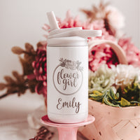 White 12 oz kids water bottle gift from bride with flower girl laser engraved and personalized with name on pink pedestal with flowers in the background  