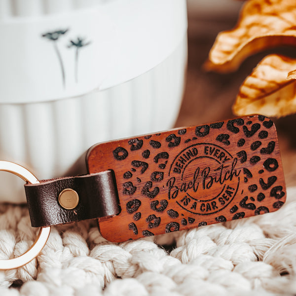Leather and Wood leopard print keychain with Behind every bad Bitch is a car seat by Legacy and Light