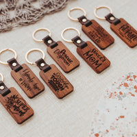 Seven mom themed keychains lined up on linen background
