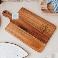 Wooden cutting board with New Home New Adventure New Memories Laser Engraved by Legacy and Light on marble surface